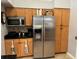 Kitchen features stainless steel refrigerator, microwave, and wood cabinetry at 3220 Town And Country Rd, Oviedo, FL 32766