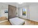 Cozy bedroom featuring a large window, mirrored wall, and light wood flooring at 4038 Hunters Park Ln, Orlando, FL 32837