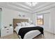 Modern bedroom with a tray ceiling, plush bedding, and a large window offering natural light at 4038 Hunters Park Ln, Orlando, FL 32837