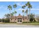 A gated community center with lush landscaping and palm trees on a sunny day at 4038 Hunters Park Ln, Orlando, FL 32837