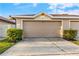 Attached two car garage in neutral color with manicured landscaping around the driveway at 4038 Hunters Park Ln, Orlando, FL 32837