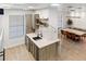 Modern kitchen with stainless steel appliances, quartz countertops, and an open layout leading to the dining area at 4038 Hunters Park Ln, Orlando, FL 32837