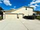 Side view of a house showcasing a three-car garage and well-maintained landscaping at 4113 Golden Willow Cir, Apopka, FL 32712