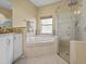 Elegant bathroom featuring a soaking tub with tile surround and a separate glass-enclosed shower at 4119 Navigator Way, Kissimmee, FL 34746