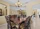 Elegant dining room featuring a tray ceiling, elegant chandelier, and a large dark wood dining table at 4119 Navigator Way, Kissimmee, FL 34746