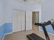 A spacious exercise room with blue walls, tile floors, and a modern treadmill, perfect for a home gym at 4119 Navigator Way, Kissimmee, FL 34746