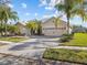 Beautiful one-story single Gathering home featuring a paved driveway, tropical landscaping, and a two-car garage at 4119 Navigator Way, Kissimmee, FL 34746