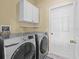 Laundry room with modern, front-load washer and dryer, and overhead cabinets for storage at 4119 Navigator Way, Kissimmee, FL 34746