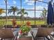 Covered outdoor patio with lounge chairs overlooking the lake at 4119 Navigator Way, Kissimmee, FL 34746