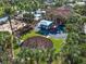 Playground with swings and slides adjacent to the community clubhouse and pool, surrounded by palm trees at 4119 Navigator Way, Kissimmee, FL 34746