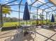 Relax on the screened porch with views of the lake, featuring tile flooring and an outdoor dining set at 4119 Navigator Way, Kissimmee, FL 34746