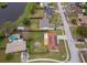 An aerial view shows a home with solar panels and fenced yard in a neighborhood with a lake and mature trees at 4303 Tomlinson Cir, Orlando, FL 32829