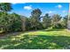 A lush green lawn and mature trees create a serene backyard setting at 4537 Woodlands Village Dr, Orlando, FL 32835