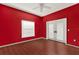 This bedroom features red walls, wood floors, and french doors leading to the exterior at 4537 Woodlands Village Dr, Orlando, FL 32835