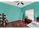 This bedroom features wood floors, a window, and light turquoise walls at 4537 Woodlands Village Dr, Orlando, FL 32835