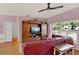 Bright living room featuring a large window, hardwood floors, TV, and a red leather sectional sofa at 4537 Woodlands Village Dr, Orlando, FL 32835