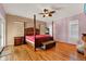 Spacious main bedroom featuring a four poster bed, bamboo flooring and natural light at 4537 Woodlands Village Dr, Orlando, FL 32835