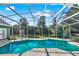 Screen enclosed pool, with blue water and view of backyard at 4537 Woodlands Village Dr, Orlando, FL 32835