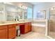 Well-lit bathroom featuring double sinks, a soaking tub, and a glass-enclosed shower for a spa-like experience at 4550 Tribute Trl, Kissimmee, FL 34746