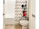 bathroom with white bathtub, toilet, and cute Mickey Mouse curtain at 4550 Tribute Trl, Kissimmee, FL 34746