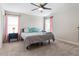 Bedroom with a ceiling fan, neutral carpet and walls, and pink curtains flanking the windows at 4622 Fairy Tale Cir, Kissimmee, FL 34746