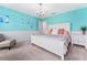 Bedroom with a vibrant blue accent wall, a white bed and furnishings, chandelier lighting, and neutral carpet at 4622 Fairy Tale Cir, Kissimmee, FL 34746