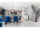 Inviting dining area with a wooden table, blue chairs, and view of the modern kitchen at 4622 Fairy Tale Cir, Kissimmee, FL 34746