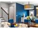 Dining room area featuring bold blue accent wall, modern lighting, and wooden staircase at 4622 Fairy Tale Cir, Kissimmee, FL 34746