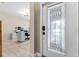 Inviting foyer with decorative glass front door, tile flooring, and view of the home office space at 4622 Fairy Tale Cir, Kissimmee, FL 34746