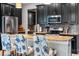 A modern kitchen features stainless steel appliances, granite countertops, and dark cabinetry with stylish bar stools at 4622 Fairy Tale Cir, Kissimmee, FL 34746