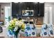 A kitchen with dark cabinets, stainless appliances and floral bar stools are shown with beautiful flowers at 4622 Fairy Tale Cir, Kissimmee, FL 34746