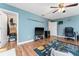 Living room with hardwood floors, ceiling fan, and blue walls at 4622 Fairy Tale Cir, Kissimmee, FL 34746