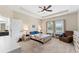 A bright main bedroom features a ceiling fan, tray ceiling, two windows, and neutral decor at 4622 Fairy Tale Cir, Kissimmee, FL 34746
