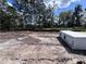 A vacant lot with tire tracks and some building materials, surrounded by tall trees under a partially cloudy sky at 5226 Prairie Preserve Run, St Cloud, FL 34772