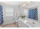 Bathroom featuring blue shower curtain, tile floors, white towels, and a large mirror at 523 Higher Combe Dr, Davenport, FL 33897