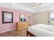 Bedroom featuring wood floors, ceiling fan, tray ceiling and a light wood dresser with TV at 523 Higher Combe Dr, Davenport, FL 33897