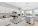 Bright kitchen features white cabinets, stainless steel appliances, and a center island at 523 Higher Combe Dr, Davenport, FL 33897