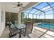 Screened lanai featuring a ceiling fan and dining area that extends to a pool with lush landscaping at 523 Higher Combe Dr, Davenport, FL 33897