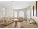 Cozy living room with comfortable seating, hardwood floors, and natural light from the windows at 523 Higher Combe Dr, Davenport, FL 33897