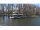 Waterfront property featuring a private dock with covered boat slips and jet skis on a tranquil lake setting at 5524 Sail Ct, Orlando, FL 32819