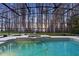 Covered pool and spa offer a serene setting with views of lush greenery and lake at 5524 Sail Ct, Orlando, FL 32819