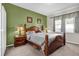 View of a bedroom with a green accent wall, a wooden bed frame and carpeted floors at 556 Grande Dr, Davenport, FL 33837