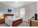 This bedroom is decorated with neutral walls, a wood framed bed, shuttered window and a classic style TV stand at 556 Grande Dr, Davenport, FL 33837