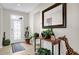 Inviting foyer with tile flooring, a decorative mirror, plants and a front door with decorative glass at 556 Grande Dr, Davenport, FL 33837