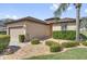 Charming single-story home with a manicured lawn, stone accents, and a two-car garage at 556 Grande Dr, Davenport, FL 33837