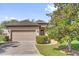 Charming single-story home with a brick driveway, two-car garage, and beautifully landscaped front yard at 556 Grande Dr, Davenport, FL 33837