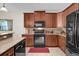 Well-equipped kitchen featuring wood cabinetry, granite countertops, and modern appliances at 556 Grande Dr, Davenport, FL 33837