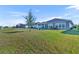 Expansive backyard with a lush lawn, fire pit, and views of neighboring homes at 585 Mosaic Blvd, Daytona Beach, FL 32124