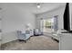 This bright bedroom includes three chairs, carpeted floors, and a large window with lots of sunlight at 585 Mosaic Blvd, Daytona Beach, FL 32124