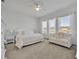 A bright primary bedroom with white decor and a sitting area with a picturesque view at 585 Mosaic Blvd, Daytona Beach, FL 32124